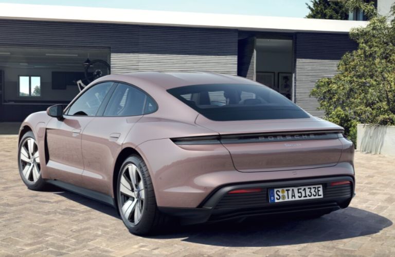 One grey color 2022 Porsche Taycan is parked outside a building.
