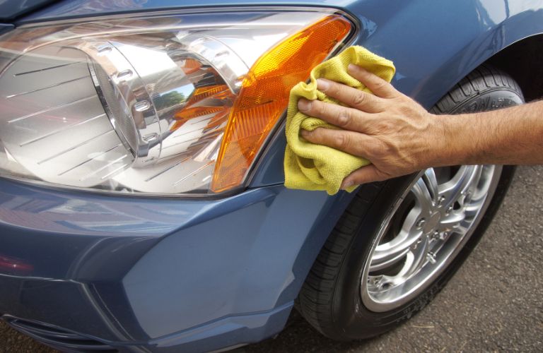 Wiping the vehicle's headlight with a microfiber cloth