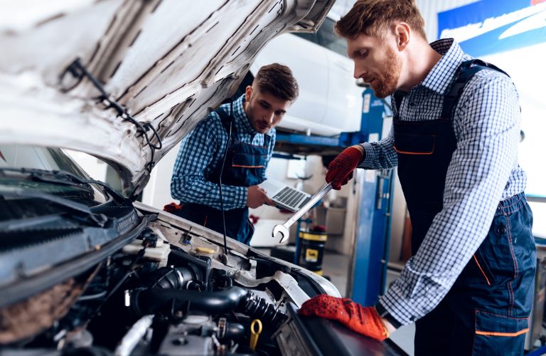 Mechanics inspecting a car engine