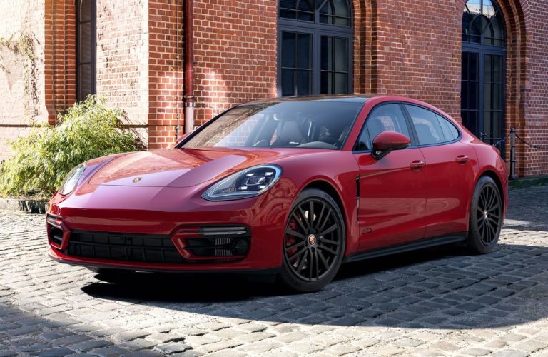 One red color 2023 Porsche Panamera is parked outside a building.
