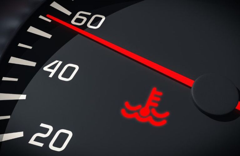 The illuminated sign of an overheated engine on the digital gauge display
